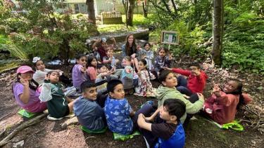 Classroom sit within a forested trail to learn about Indigenous Plants and Animals in the area