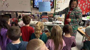 Teacher showing students donation items