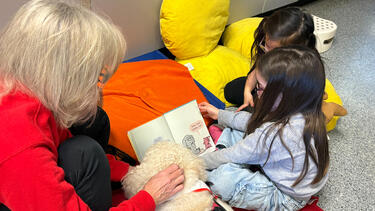 Students Reading with Kona
