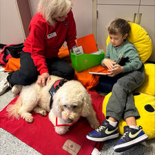 Student Reading with Kona