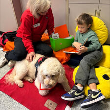 Student Reading with Kona